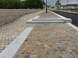 Trottoir en pavés terminé avec candélabres.